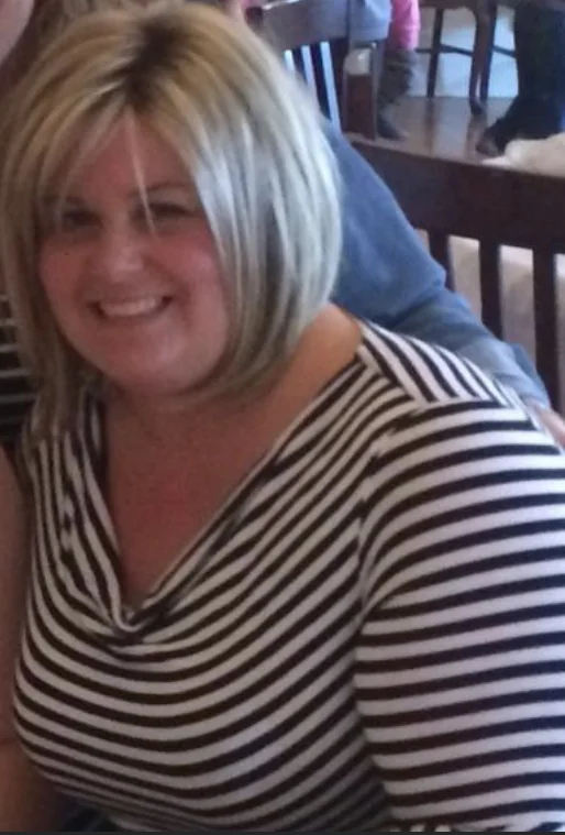 Kristal some years ago, smiling, in a striped top